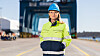 Birna Ödefors i reflexjacka och blå hjälm står på kaj vid APM Terminals Gothenburgs containerterminal.