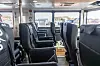 Tomma bussäten i en ljus busskupé med stora fönster.