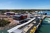 Färjeterminal med gångbroar och fartyg i en kusthamn.
