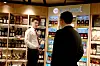 Två personer i en butik framför en hylla med Bacardi-produkter och andra flaskor.