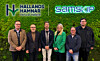 Anställda från Hallands Hamnar och Samskip framför en grön vägg.