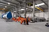 Omålade vingar under produktion till höger i bild, färdiga vingar till vänster. De orangea stålkonstruktionerna är vingfundament.